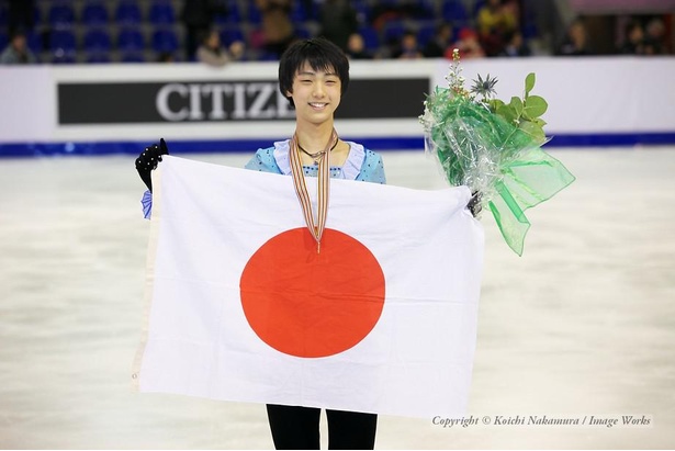 表彰式で日の丸を持つ羽生結弦