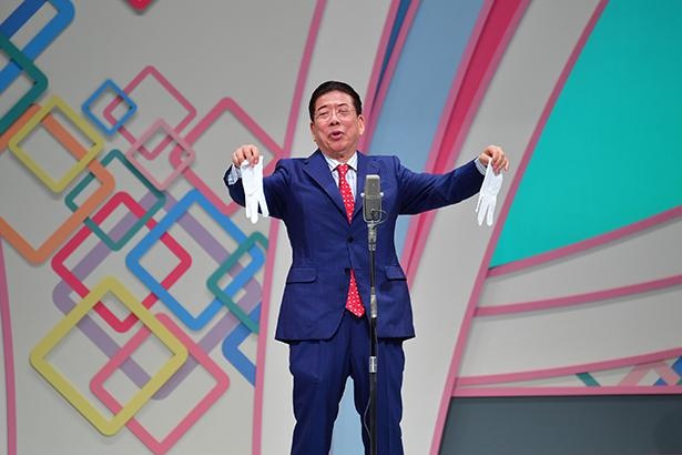 ヘレンさんから持ち歩くよう言われている手袋など、様々なグッズと共にネタを披露する西川きよしさん