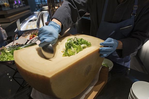 シーザーサラダのライブステーションでは、大きな塊の器から大胆にチーズを削り出す！