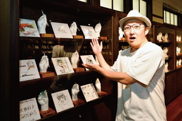マンガミュージアムに来館した漫画家の手をかたどった石膏手型をイラスト入りのサイン色紙と共に展示。その数なんと100人以上！ /京都国際マンガミュージアム