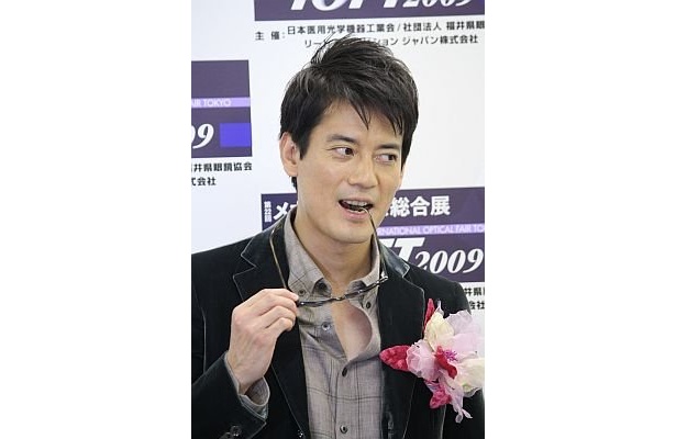 報道陣のムチャぶりに応え、サングラスをかんでみせる唐沢さん