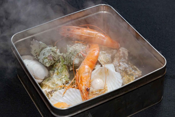【写真】半斗缶に牡蠣を入れ、缶のまま直火にかけて蒸し焼きにする豪快な浜料理「ガンガン焼き」