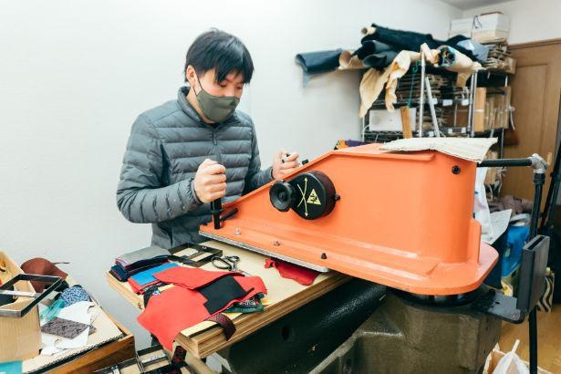 「印傳の山本」工房内で生産工程を解説する山本裕輔氏