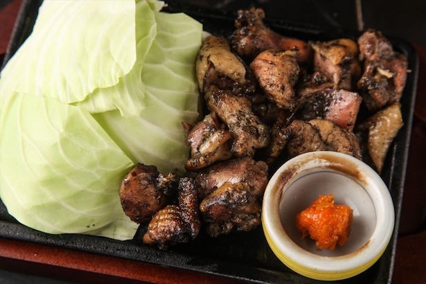 【写真を見る】鶏肉を網に乗せて炙り、鶏の脂を炭に落としながら、豪快な炎で焼きあげる宮崎名物の「ごろ焼き」