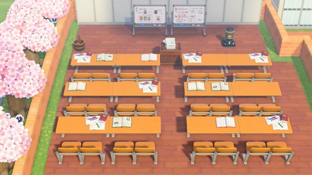 机がきっちり並んだ講義室。横に咲く桜も相まって、ノスタルジックな雰囲気