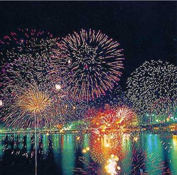 沖合に浮かぶ2隻の舟から打ち上げる花火が、海面に映えて美しい