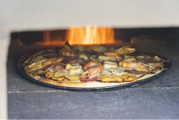 ピザ窯でピザ作り。250度程度と高温で、短時間で焼けるのがおいしさの秘密