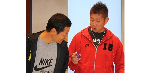 待ち時間に、必勝お守りを身ながら談笑する2人