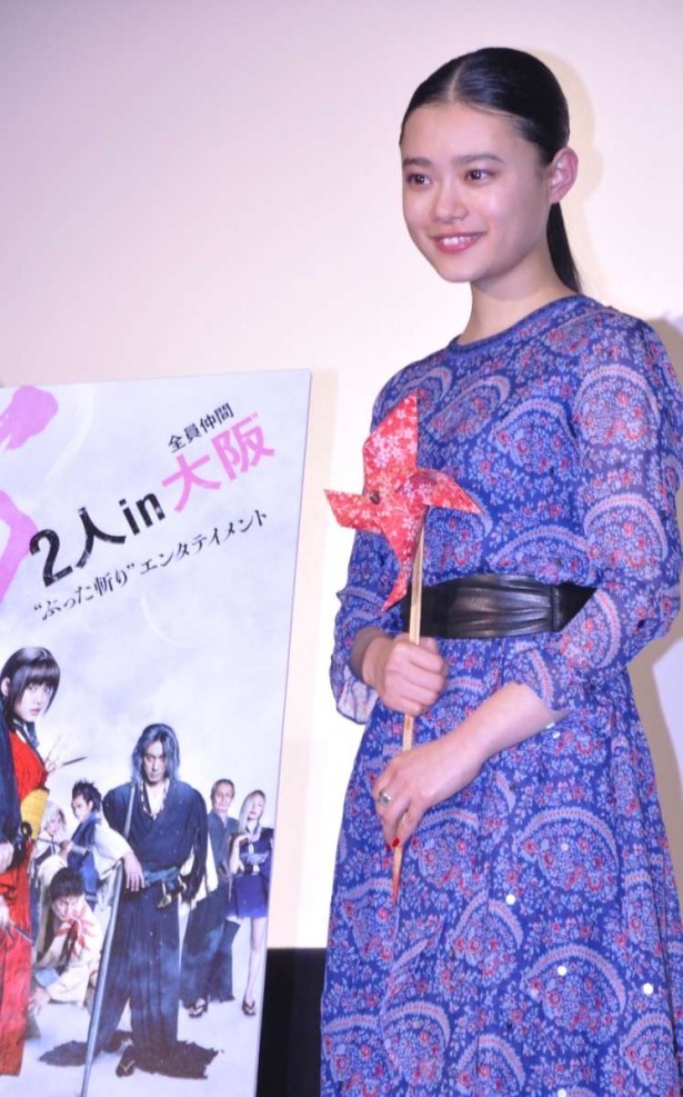 映画で使われた小道具の赤い風車を手に、記念撮影に応じる杉咲花