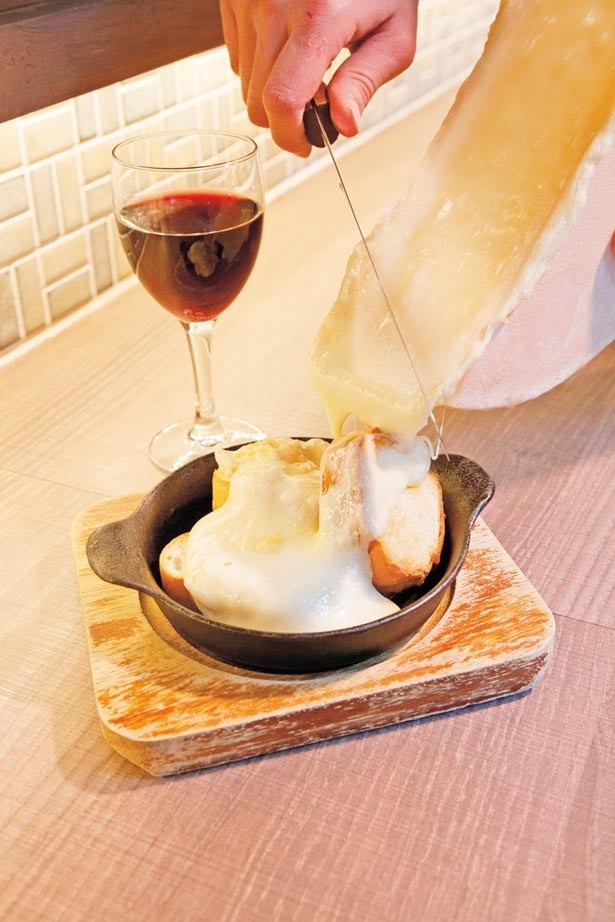 目の前でバゲットに垂らされる「自称、大阪最安値！」の「ラクレットチーズ」(500円)はかなりのボリューム/立ち呑みビストロ やまもと