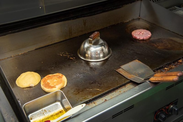 メロンパンとパティの間にあるステーキカバーの中では、オニオンが焼かれている