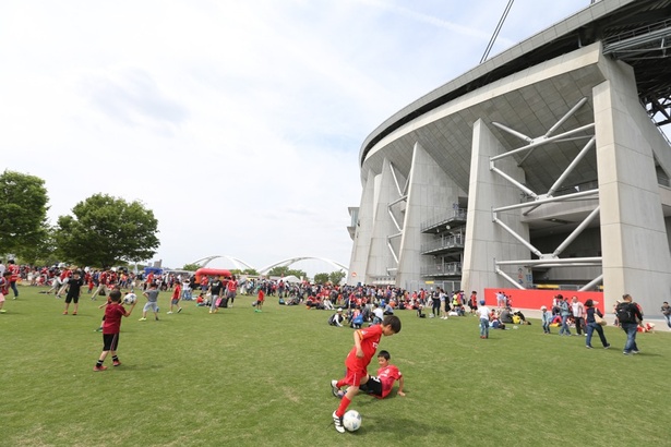 試合前の芝生広場でサッカーに興じる子どもたち