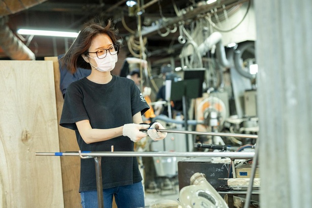 作業中の小笠原さん。溶解炉、再加熱炉から発する熱によって工場内は常に暑い