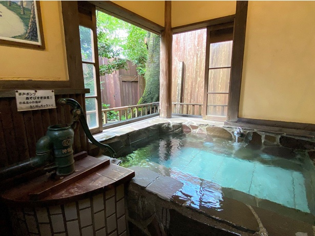 家族貸切露天風呂「楽」は、昭和レトロな雰囲気。石造りの浴槽から、外の木々を眺めることができ爽快。珍しい井戸ポンプも置かれている