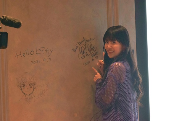 EJアニメホテルを訪れた証としてロビーの壁にサインを残す場面も