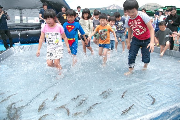 ヤマメのつかみ取り大会。全身濡れるのを覚悟で魚を追い回す子ども達。中には1人で数匹捕まえる子も。終わった後はそのまま水遊び