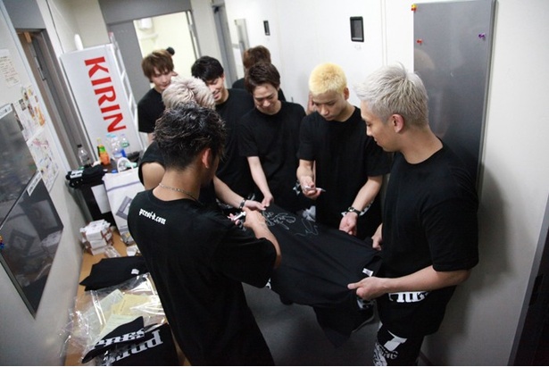 終演後にTシャツにサインを書くメンバー