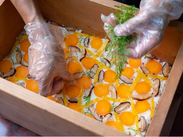 柚子酢を混ぜたご飯とシイタケ、ニンジン、錦糸卵などを重ねていく