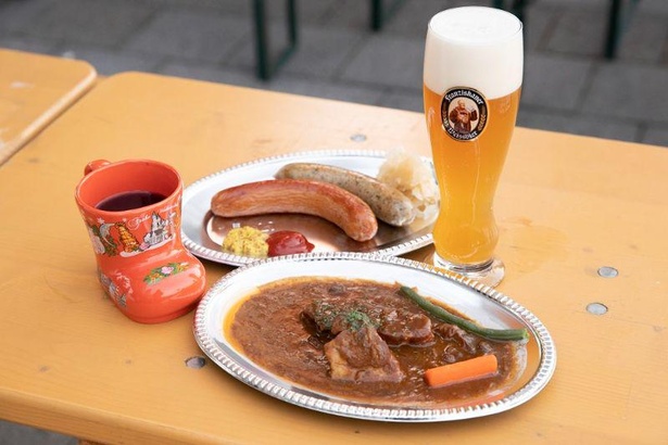 クリスマスマーケットのメニュー。写真手前は、ドイツの国民食のひとつで、柔らかいお肉が堪能できる「ザワーブラーデン」(1800円)