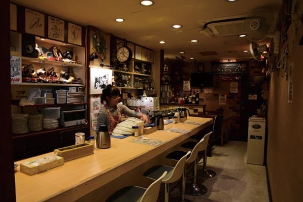 カウンター席と奥にはテーブル席も。店主の趣味だという、車やカメラをディスプレー/フライ専門店 双平