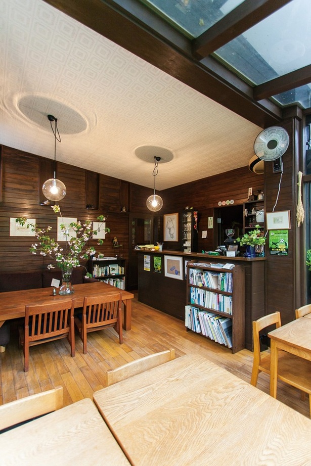 「cafe kaeru」の店内。ガラス張りになった窓際の席からは、緑いっぱいの庭園も眺められる
