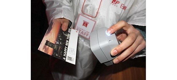 年賀ハガキに貼ったQRコードを、スタッフに渡して読み込んでもらうと…