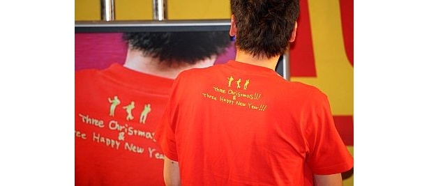 Tシャツのバックには“Three Christmas”の文字