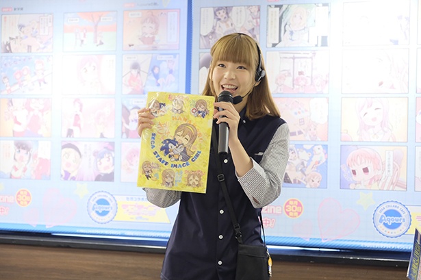 LINEスタンプのデザインを使ったクリアポスターを紹介する高槻さん