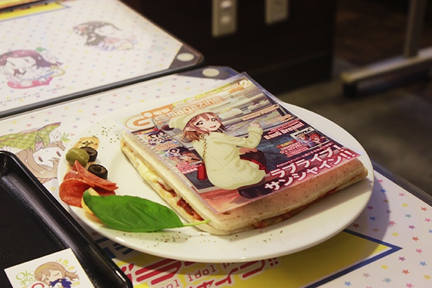 「ボリューム満点！電撃G’s magazineサンド」(1200円)。上に乗った表紙は全7種。どの絵柄かはテーブルに届くまでわからない