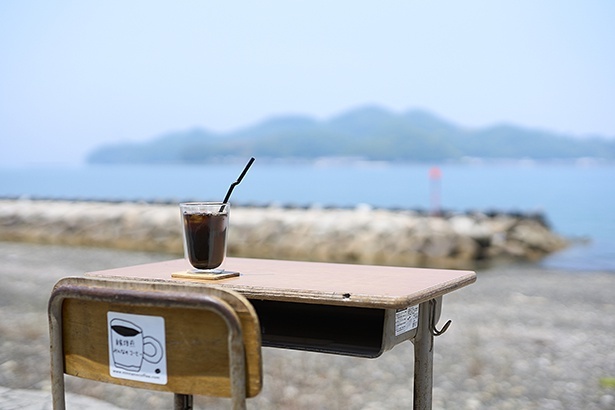 学校で使われていた机と椅子を岸壁に設置。海と大島を間近に望む、1席だけの特等席だ