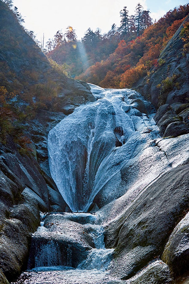 “女滝”と呼ばれる桃洞渓谷のシンボル。岩肌を滑り落ちる優美な姿と、赤や黄に色付く木々のコントラストは必見だ