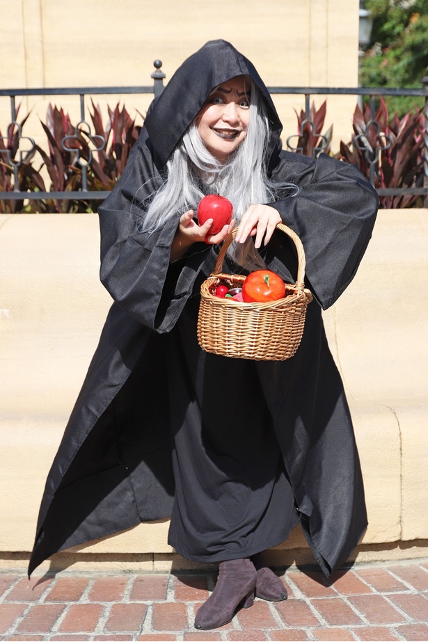 「白雪姫」の老婆、ウィックド・ウィッチに扮し、毒リンゴを差し出すゲスト