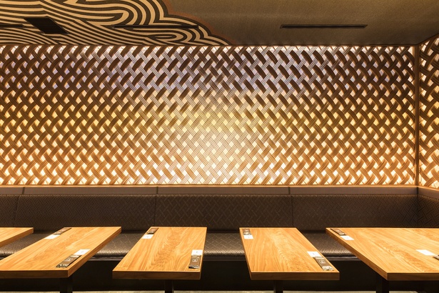 テーブル席の壁面は銀座の空をイメージ。織物と木工格子が合わせられている。スタイリッシュなテーブルが雰囲気とマッチ