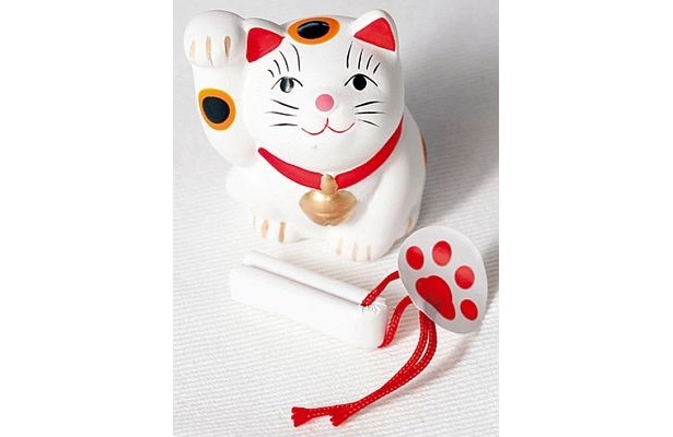 ｢吉兆招福亭｣の招き猫おみくじ(300円)。右手でお金、左手で人を招く招き猫。両手で招く欲張りな猫も！ おみくじは底に入っていて肉球シールで封がしてある