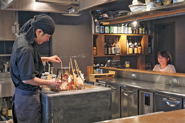 囲炉裏は店内中央に配置。カウンター席に座ればこんなに近くに！温かい炎でムードも満点/いろり焼き かるた