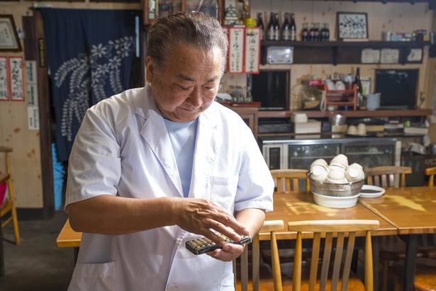 4代目の久嗣さんは料理の専門学校を卒業後、20歳から42年間店を守り続けている。会計はそろばんを弾く昔ながらのスタイル