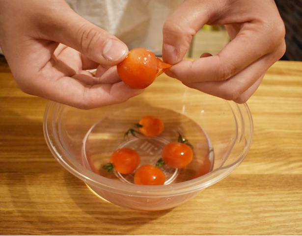 2.冷凍したミニトマトを水にさらし、薄皮を剥く