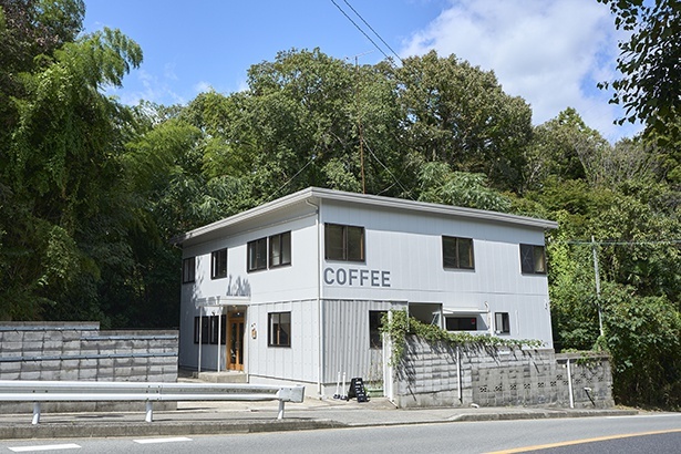 白亜の建物にCOFFEEの文字が目を引く「ridge」。店の前にはその名も「峠」のバス停がある