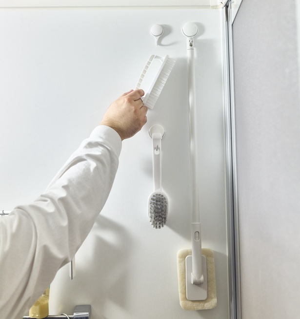掃除道具は右端にまとめて壁収納。ブラシやスポンジの水切りがしやすい。