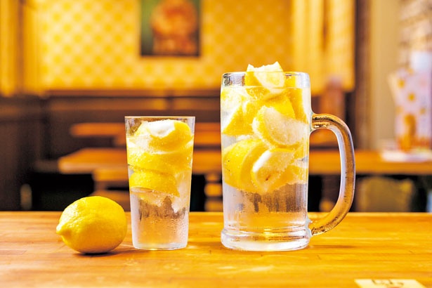 【写真を見る】「名物レモンサワー」(左・626円)、「メガレモンサワー」(右・1058円)。凍らせたレモンを使う強炭酸の一杯/酒場エビス
