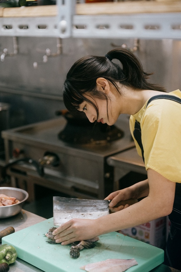 【写真を見る】丸魚を手際よく捌いていく門脇麦「魚料理は家でもよく作るので」と余裕の表情