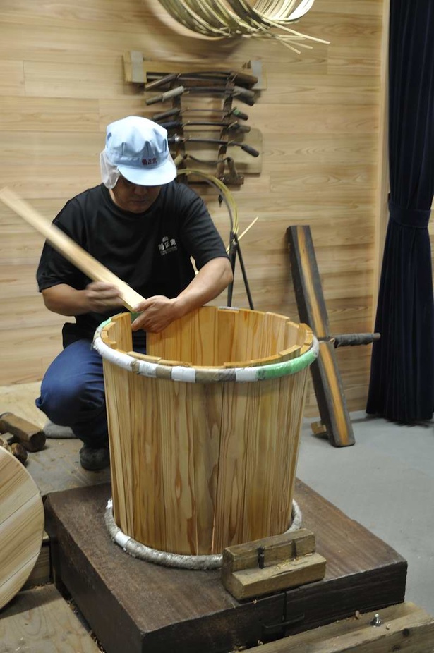 酒樽作りの実演中。樹齢100年以上の杉を削った榑(くれ)と呼ばれる板を組み合わせて樽の側面が作られる