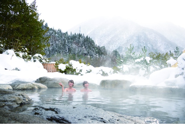 開放感あふれる露天風呂で、源泉かけ流しの湯を堪能できる。奥飛騨の山々と蒲田川を望む