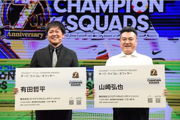 【写真を見る】特大サイズの名刺を手に、チーフ・ウイコレ・オフィサー就任の喜びを語る有田哲平さんと山崎弘也さん