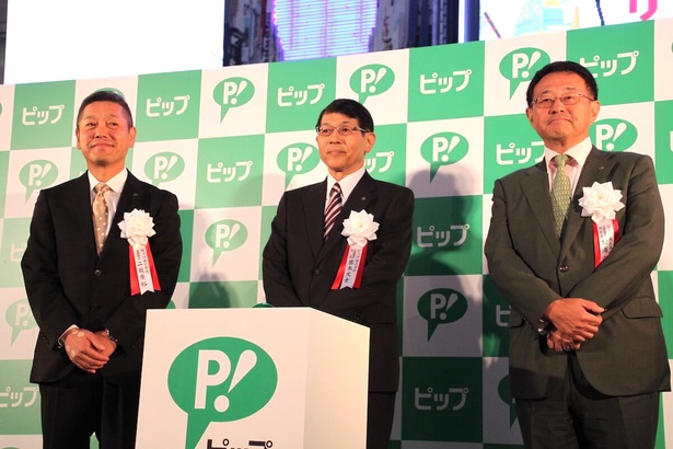 点灯式に登壇した同社の藤本久士社長（中央）、松浦由治副社長（右）、商品開発事業本部長の二瓶康裕氏（左）