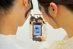 鏡の前に立ち、スマホで撮影すると簡単に自撮りができる