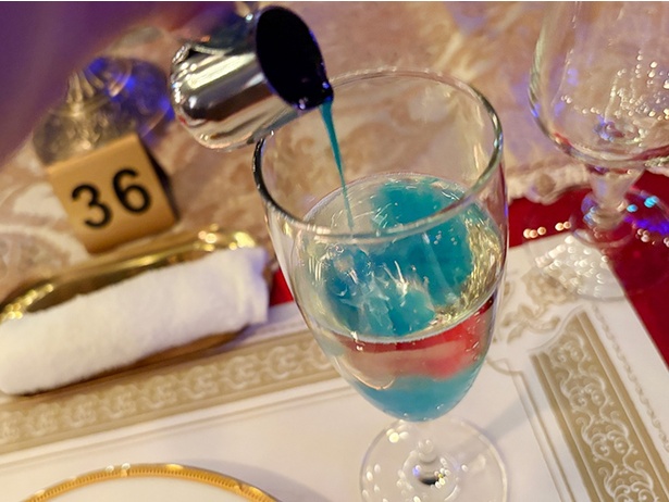 席に用意されていたシロップを飲み物に入れると…透明だったスパークリングワインが青色に変化！