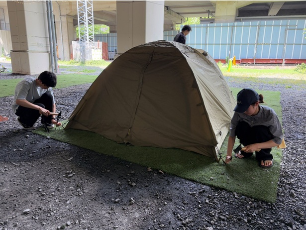 テントが組みあがったら、ハンマーとペグを使ってテントを地面に固定する