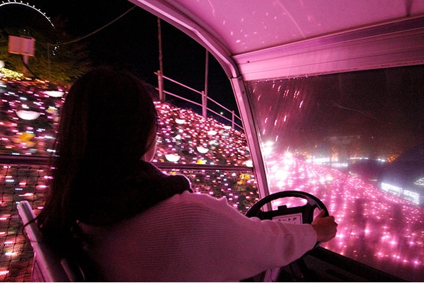 【写真を見る】光の花畑をドライブする「バンピーカート」。ピンクに輝く花々に囲まれた幻想的な雰囲気を楽しめる