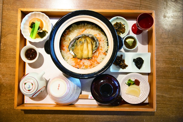 土鍋で炊いた釜めしにアワビがのる、姿煮あわび釜飯(3300円)は11時30分からの昼げメニュー。半分はそのまま、残りはダシをかけて味わおう
